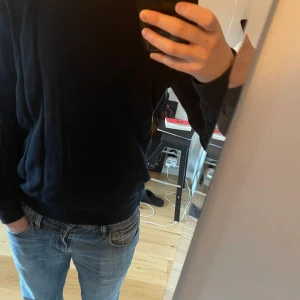 Blå tröja från H&M - Säljer en stilren marinblå tröja från H&M i slim fit. Tröjan har långa ärmar och är perfekt för en enkel och snygg stil. 