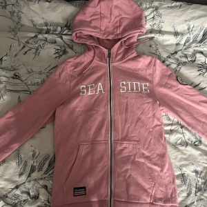 Rosa zip up hoodie - Säljer den här super fina zip up hoodien då den inte kommer till användning! Ge gärna prisförslag! Den sitter som en xs/s. Vet tyvärr inte märket men det står seaside på lappen❤️