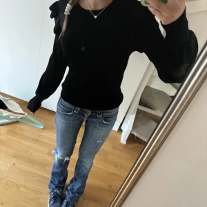 Svart tröja från VILA - Snygg svart tröja från VILA med volangdetaljer på axlarna. Använd en gång, nypris 700kr