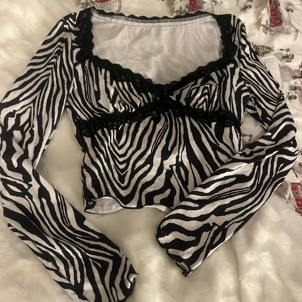 Snygg zebramönstrad topp från Shein med långa ärmar och spetsdetaljer. Perfekt för en trendig look med sin svartvita design. Köpte den endast för en djurtema fest, sedan dess aldrig använt . Yläosat.