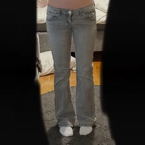 Grå lågmidjade bootcut jeans - Snygga gråa lågmidjade bootcut jeans med
 vita sömmar och snygga fickor! Använda men
 jättebra skick som tyvärr inte kommer till
 användning för mig längre💕💕 stl tall 158
 