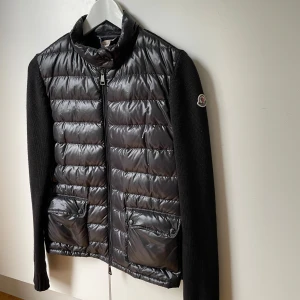 Svart Moncler cardigan  - Svart Moncler cardigan i mycket bra skick. Stickade ärmar och dragkedja framtill. Perfekt för kyligare dagar. Hör gärna av dig vid frågor och funderingar. Jag har även kvitto på jackan om det önskas. 