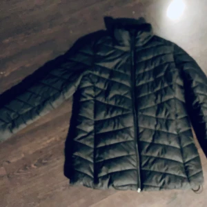 Svart pufferjacka från Tuxer - Säljer en svart pufferjacka från Tuxer i storlek M. Jackan har en dragkedja framtill och är perfekt för kyligare väder. Den quiltade designen ger extra värme och stil.