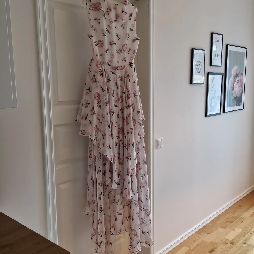 Säljer en vacker blommig långklänning från Y.A.S. Klänningen har volanger och en omlott-design med en romantisk känsla. Perfekt för sommarens festligheter.. Mekot.