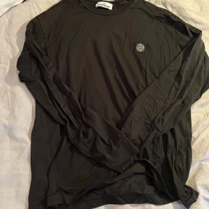 Stone Island Långärmad T-shirt - Säljer en fin stone island långärmad t-shirt i färgen svart, storlek XL,  Den är köpt på nk, kvitto medföljer ej.