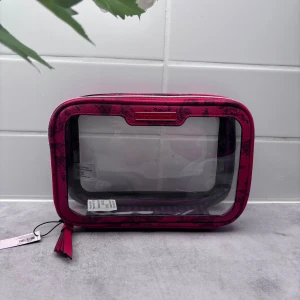 Transparent necessär från Victoria's Secret - Säljer en superfin transparent necessär från Victoria's Secret. Ny och original med  en snygg röda kant med ett blommigt mönster och en praktisk dragkedja. Perfekt för att hålla ordning på dina smink- och hygienprodukter när du reser!