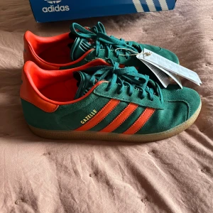 Adidas gazelle - Helt oanvända med lappen kvar adidas gazelle gröna med oranga detaljer! Orginalpris är 1300 och säljer för 900, strl 38 2/3😙