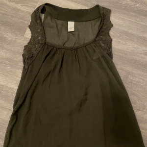 Spets linne - Jättefint spets linne i mesh material så genomskinligt med. Flowigt material så passar från xs-s 😊. Fin mörkgrön till hösten. Nyskick, i princip oanvänt!