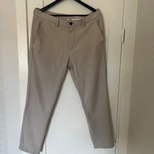 Säljer ett par stilrena beige chinos från Zara. De är i storlek EUR 42/US 32 och tillverkade i Turkiet. Perfekta för både vardag och lite mer uppklädda tillfällen. Byxorna har en klassisk design med fickor fram och bak samt en knapp och dragkedja i gylfen.