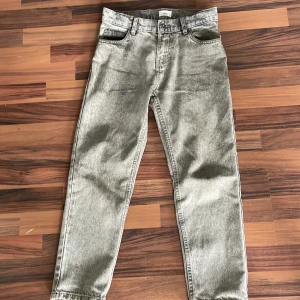 Grå jeans från Grunt - Säljer ett par grå jeans från Grunt i storlek 24. De har en klassisk femficksdesign och är i en straight passform. Perfekta för en avslappnad vardagslook! ps har ett hål på höger sida i fickan.