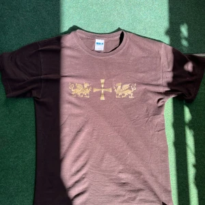 Dope vintage-gildan tisha mörkbrun - Print med kors och drakar på båda sidor. Printet är i bra skick nägra mindre hål på ena armen