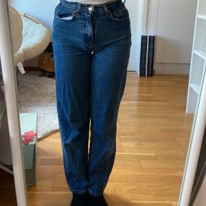 Blå jeans med hög midja - Säljer ett par snygga blå jeans med hög midja. De har en klassisk straight fit. Jeansen är i bra skick och har en knapp och dragkedja framtill.
