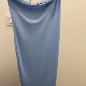 Ljusblå axelbandslös klänning från SHEIN - Säljer en superfin ljusblå klänning från SHEIN i S. Den är axelbandslös och har en tight passform som verkligen framhäver figuren. Perfekt för sommarens fester eller en kväll ute. Klänningen är lång och gjord i ett mjukt och stretchigt material. Klänningen är i jättebra skick och aldrig använd.