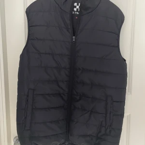 Dunväst - En väst från X-Trail. Köpt för 399kr i höstas. Säljer då jag aldrig använder den. Str M. Enda defekten är det lilla bandet i kragen som rycktes av. 