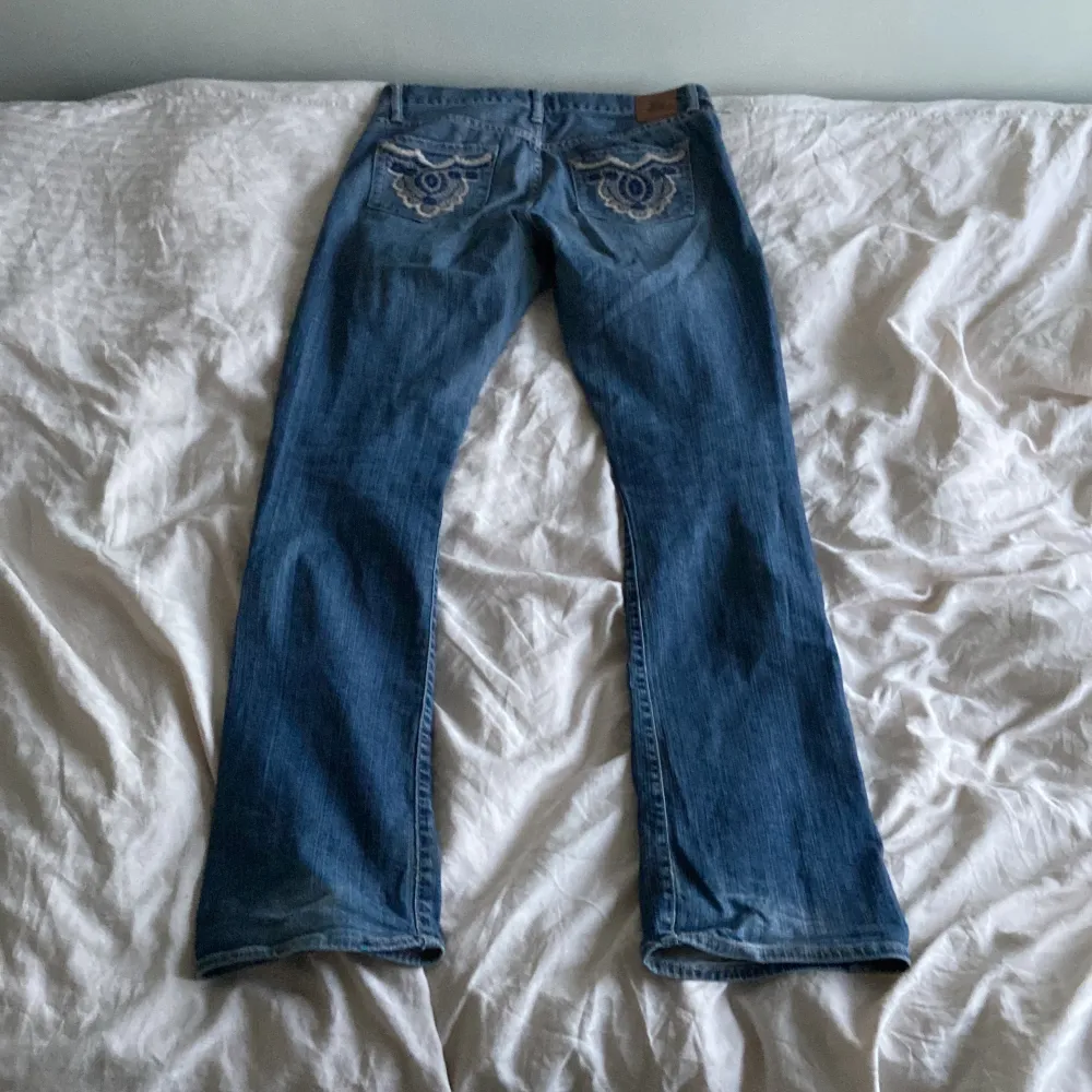 Lågmidjade bootcut jeans med fina mönster på båda bakfickorna. Väll använda men i gott skick🤗. Jeans & Byxor.