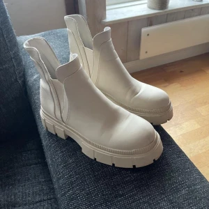 Vita boots - Snygga vita boots med grov sula och elastiska paneler på sidorna för enkel på- och avtagning. Perfekta för en stilren look.