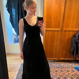 Svart strandklänning från calzedonia - Elegant svart lång strandklänning med v-ringad hals och ärmlös design. Perfekt för en stilren look. Klänningen har en smickrande passform och är tillverkad i ett mjukt material som ger ett fint fall. Priset kan diskuteras🥰