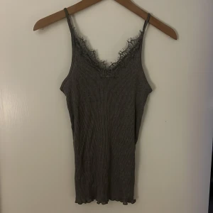 Grå ribbad linnetopp med spetsdetaljer - Snygg grå ribbad linnetopp med spetsdetaljer vid halsringningen🫶aldrig använd, inga defekter✨