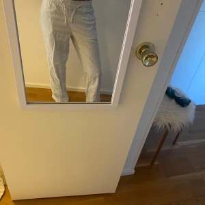 Randiga byxor med dragsko - Snygga och bekväma randiga byxor i ljus färg med dragsko i midjan. Perfekta för en avslappnad stil. Byxorna har en rak passform och är tillverkade i ett lätt material.