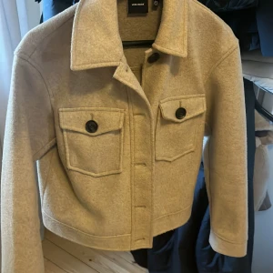 Beige jacka från Vero Moda - Snygg beige jacka från Vero Moda med knappar framtill och två bröstfickor. Jackan är perfekt för höst och vår. Den är tillverkad i ett mjukt material som ger en stilren look. Använd men fortfarande mycket bra skick!💕