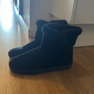 Svarta boots med foder - Säljer ett par svarta boots med mjukt foder. Perfekta för kalla dagar med sin varma insida. De har en enkel design utan snörning eller dragkedja. Dem är från newyorwker