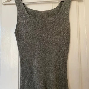 Glittrig  topp - Snygg glittrig ärmlös topp i silver💞 en liten defekt på bild 3! Bortsett från det mycket bra skick!