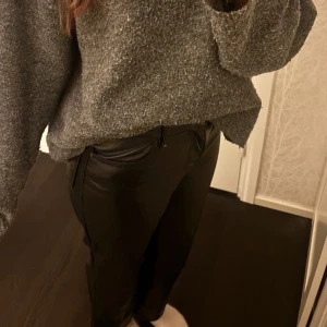 Svarta skinnbyxor - Snygga svarta skinnbyxor med en tight passform. Perfekta för en trendig look. Byxorna har en klassisk design med dragkedja och knappar framtill.