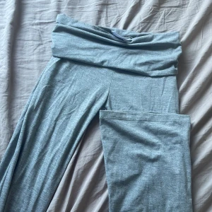Yoga Byxor från Gina Tricot - Säljer ett par bekväma grå mjukisbyxor från Gina Tricot. Byxorna har en bred midja som kan vikas ner för extra komfort. Perfekta för en avslappnad dag hemma eller på språng. 