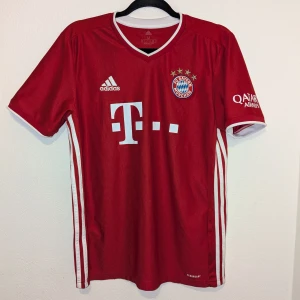 Röd FC Bayern München fotbollströja från Adidas - Säljer en röd FC Bayern München fotbollströja från Adidas med korta ärmar. Tröjan har vita detaljer och logotyper på framsidan samt texten 'FC Bayern München' på baksidan. Perfekt för fans av laget! 🏆 Använde den några gånger men sen den passa inte längre. Den är lite sliten vid bild 5 men annars i perfekt form. Kan diskuteras om ett bra pris 😊