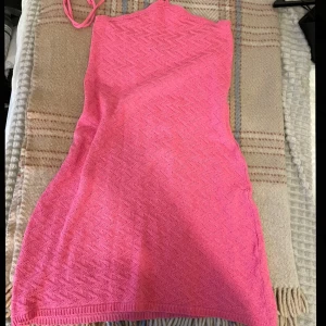 Rosa stickad klänning - Säljer en söt rosa stickad klänning med halterneck-design, även öppen i ryggen💕 använd endast 1 gång 🤗Pris diskuteras!!