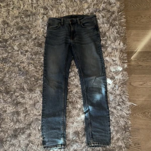 Blå jeans från Nudie Jeans - Säljer ett par snygga blå jeans från Nudie Jeans Co. De har en klassisk femficksdesign och en bekväm passform med modellen Lean Dean.