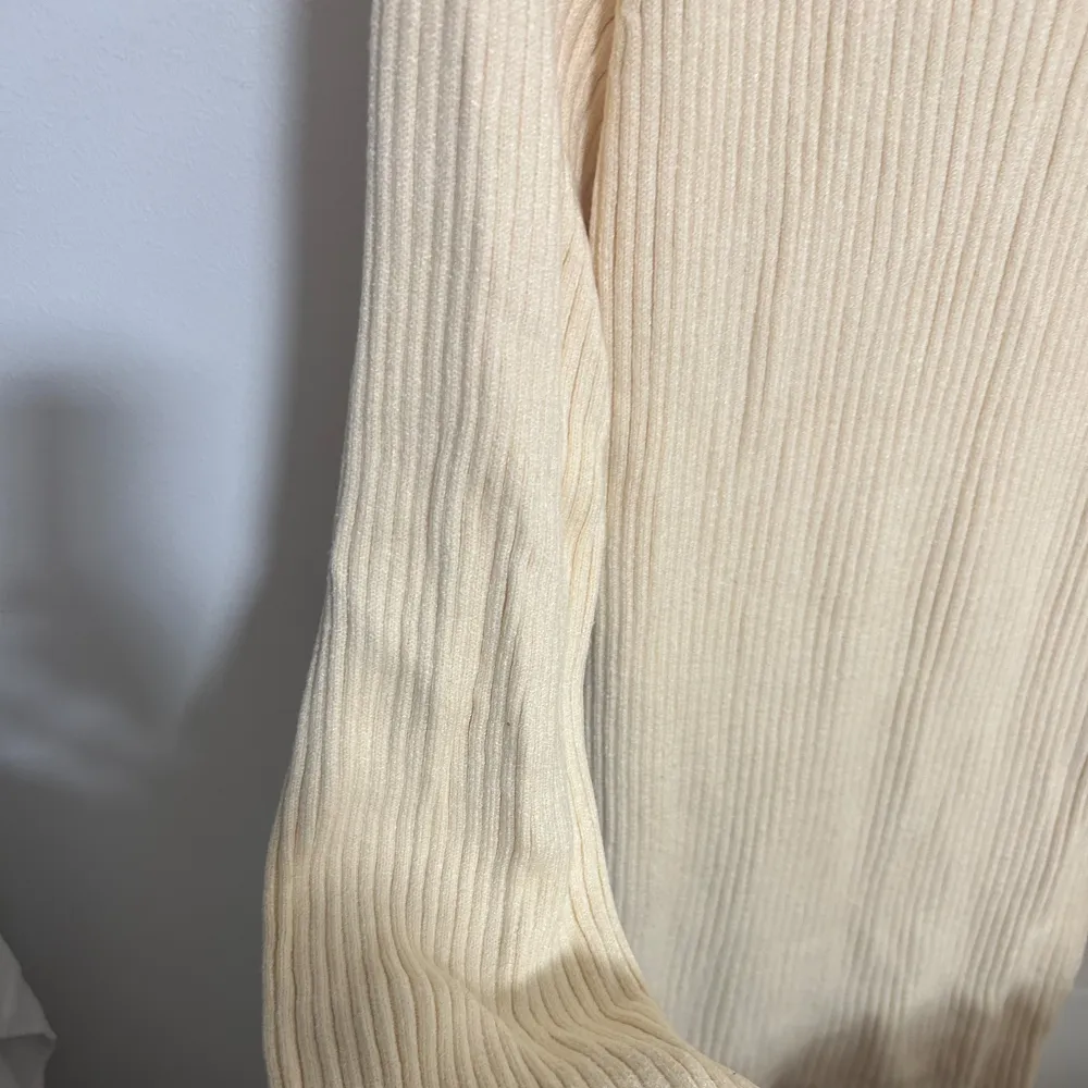 Säljer en stilren beige polo klänning med ribbad struktur. Klänningen har långa ärmar och en hög polokrage som ger en mysig känsla. Den är midi lång . Mekot.