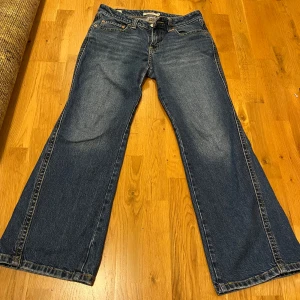 Blå jeans från Levi's - Säljer ett par klassiska blå Levi's jeans med bootcut-stil. De har en knappgylf och femficksdesign. Perfekta för en avslappnad look. De är väl nvänd men fortfarande i väldigt bra skick😊köpta för 1500