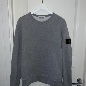 Grå sweatshirt från Stone Island - Säljer en grå sweatshirt från Stone Island. Tröjan är storlek M och är i bra skick (använd fåtal gånger). Tröjan passar s/m skulle ja säga. Köpt på Stone Island butik i Stockholm för några år sedan. 