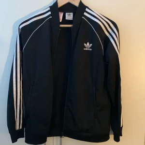 Svart träningsjacka från Adidas - Adidas sst tröja/fleece. Nypris 400 mitt pris 129. Nyskick. Kom dm för prisförslag eller frågor.