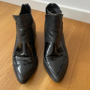 Hope boots i svart skinn och lack - Hope boots i svart skinn och lack. Storlek 38. Skick, använda med spår av användning. Lite bruksslitage. Rökfritt hem. Skickar paket som spårbart.