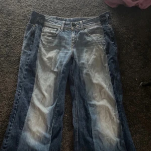 Blå jeansbyxor från Hilfiger - Snygga blå jeansbyxor från Hilfiger med en klassisk femficksdesign. Byxorna har en något sliten look med ljusare partier framtill och en läderpatch med logotyp baktill. Perfekta för en avslappnad stil. Är hemmasydda baggy jeans passar perfekt baggy på en M. Passat mig som är 165cm