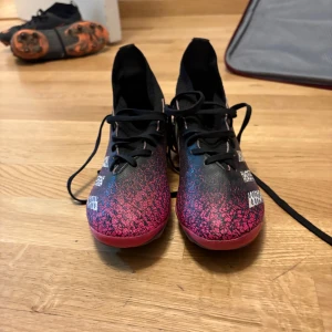 Adidas Predator fotbollsskor - Snygga Adidas Predator fotbollsskor i svart och rosa med snörning. Skorna har en hög ankelkrage för extra stöd och en iögonfallande design med vita detaljer. Perfekta för fotbollsplanen. Är använda ett fåtal gånger. Sälj pågrund av för liten storlek