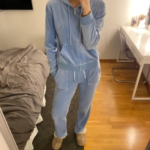 Ljusblått Juicy couture set  - Säljer mitt ljusblåa Juicy set. Byxorna är i storlek S och tröjan i storlek M. Byxorn har lite fläckar längst ner på baksidan av benen. 