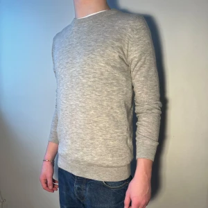 Tröja från Samsøe Samsøe  - Säljer en stilren grå stickad tröja från Samsøe Samsøe. Tröjan har en klassisk rund hals och långa armar. Storlek S men sitter som XS.