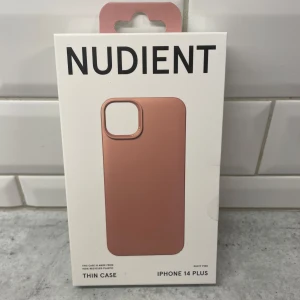 iPhone 14 Plus mobilskal - Helt oanvänt mobilskal från märket Nudient i färgen ”dusty pink”. Gjord för Iphone 14 plus.  Nypris på deras officiella hemsida ca 350kr.  Information - 100% återvunnen plast - Ultratunn design (1mm) - Mjukt premium mikrofiberinlägg - Kompatibel med trådlös laddning - Designad av Jesper Ståhl  Förpackning aldrig öppnad så precis som från butik 10/10 skick.  Pris kan diskuteras vid snabb affär!