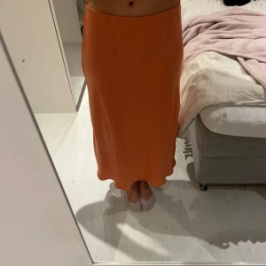 Kjol - Fin kjol i en härlig somrig färg🧡vet inte riktigt vad materialet heter men nästan som satin fast de skrynklas aldrig så man behöver inte stryka den.