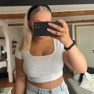 Vit croppad topp från Shein - Säljer en vit croppad topp från Shein. Toppen har korta ärmar och en enkel design som passar perfekt till jeans eller kjol. Perfekt för varma dagar eller som en basplagg i garderoben. Aldrig använd bara provad.