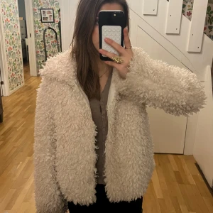 Beige fluffjacka - Mysig gräddvit teddyjacka som är helt slutsåld🩷.  Jackan har en enkel och stilren look som passar till många olika outfits. 