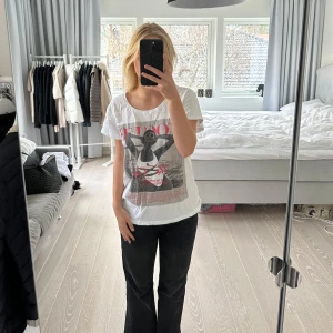 Vit t-shirt med Vogue-tryck - Säljer en vit t-shirt från Black Book med ett stort Vogue-tryck på framsidan. T-shirten har korta ärmar och en rund halsringning. Perfekt för en avslappnad stil.