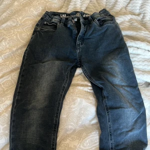 Mörkblå jeans från LAB Industries för pojke - Snygga mörkblå jeans från LAB Industries med slim fit passform. De har en klassisk femficksdesign och dragkedja. Perfekta för en stilren look.