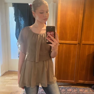 Beige blus från Stockholm - Säljer en elegant beige blus från Stockholm. Blusen har korta, fladdriga ärmar och en lös passform med ett fint fall. Perfekt för en stilren look. Blusen är för perfekt användning till fester eller när man ska ut men den passar också för vardagen. Blusen har en y2k look och är lite ”klänning aktig”. Priset kan diskuteras💕🥰
