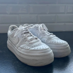 Vita Nike sneakers - Säljer ett par klassiska vita Nike sneakers. De har en stilren design med snörning och perforerade detaljer på ovansidan för ventilation. Perfekta för en avslappnad stil. !Tvättas såklart innan de skickas iväg! Bra pris ✅
