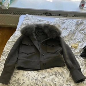 Meotine jacka grå - Grå meotine jacka, jätte bra skick bara att ena knappen vid handen har avlossnat men det är inget man märker. Om priv gör fler bilder