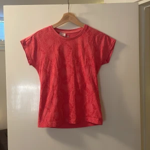 Rosa t-shirt från Adidas - Säljer en snygg rosa t-shirt från Adidas med ett subtilt mönster. T-shirten har korta ärmar och en rund halsringning. Perfekt för en sportig look eller en avslappnad dag. Passar bra till jeans eller träningsbyxor. 🌸